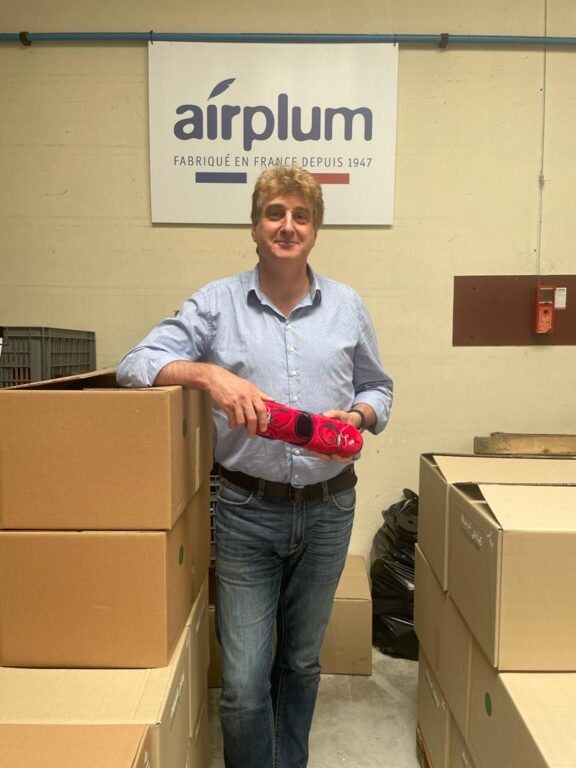 Frédéric Guiral de Haas tenant des chaussons Airplum rouge