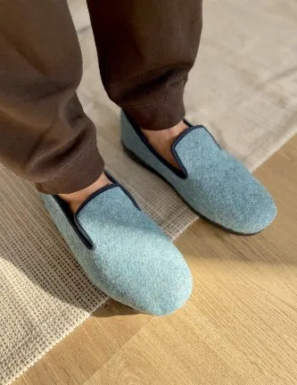 pieds d’un homme avec des pantoufles bleues